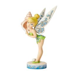 Simpática figura de Campanilla con una concha marina escuchando el mar con una altura aproximada de 16 cm., disfruta del hada más famosa de la factoría Disney 