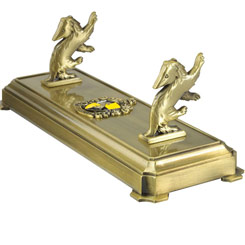 Dado que las varitas mágicas no se pueden tener en cualquier lado, aquí tienes un práctico y precioso soporte de metal fundido basado en el Escudo de Hufflepuff para sostener tu varita preferida, ideal para decorar tu hogar.