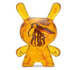 La figura Dunny de resina ámbar parece guardar un instante detenido bajo luz cálida. Su acabado translúcido, con un insecto preservado visualmente en el interior, convierte esta pieza coleccionable de 20 cm en un objeto con presencia propia