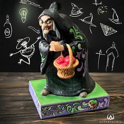 Con una apariencia siniestra, la malvada bruja se oculta en las sombras disfrazada de anciana. Su manto negro, decorado con los vibrantes rosemaling de Jim Shore, contrasta con la canasta llena de manzanas envenenadas que lleva. 