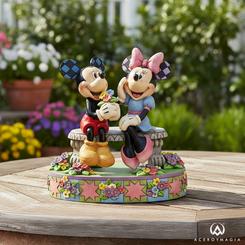 En un banco de ensueño bajo un tapiz de flores multicolor, Mickey regala a Minnie un ramo recién cortado mientras ella sonríe ruborizada, capturando la magia de un momento lleno de ternura gracias al estilo único de Jim Shore. 