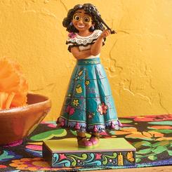 Mirabel Madrigal cobra vida en este delicado busto de 13 cm obra de Jim Shore: con su característico gesto alegre, sostiene un mechón de su rizado cabello mientras su falda bordada se funde en coloridos motivos