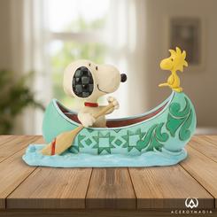 Aventura a dos remos con aire artesanal: Snoopy & Woodstock en Canoa es una figura de resina de piedra delicadamente esculpida y pintada a mano por Jim Shore, con los característicos patrones rosemaling y “quilt”