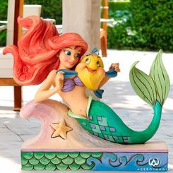 Adéntrate en el mágico reino submarino de Disney con la preciosa figura de Ariel y Flounder, inspirada en el clásico "La Sirenita" de 1989. El talentoso artista Jim Shore ha dado vida a esta encantadora figura de Ariel