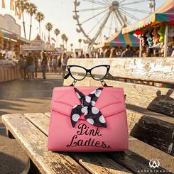 Rosa chicle con actitud de los 50 y espíritu Rydell en cada detalle: el Bolso Ladies Grease Loungefly luce el bordado Pink Ladies, un pañuelo de lunares anudado en la solapa y una asa superior con forma de gafas cat-eye 