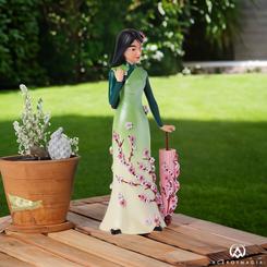 Explora la gracia y la valentía de Mulan con la Figura Botánica de la colección Disney Showcase. Esta cautivadora pieza captura la esencia de la icónica princesa de Disney, vistiendo su hermoso vestido verde degradado adornado con delicados pétalos