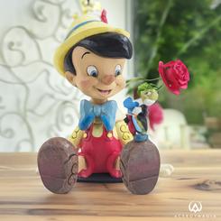 Jiminy Cricket es bastante elegante en este diseño de Jim Shore, dando una punta de su sombrero de copa mientras sonríe y le da a su mejor amigo Pinocho una lección sobre las tentaciones.