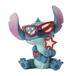Un estallido de orgullo estadounidense llega a tu colección con la figura de Stitch de Jim Shore, de 13 cm de altura, moldeada en resina pintada a mano y luciendo unas llamativas gafas con diseño de estrellas y franjas
