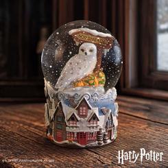 La nieve queda suspendida sobre la aldea como si el invierno se hubiera detenido dentro del cristal. La bola de nieve Hogsmeade Village 15 cm reúne a Hedwig, el cartel del pueblo y una base repleta de casas nevadas en una pieza 