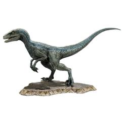 La figura Blue Jurassic World parece detenerse un segundo antes de saltar fuera de la vitrina. Su silueta alargada, la mirada amarilla y la franja azul del lomo convierten esta estatua de velociraptor Blue en una pieza con presencia inmediata.