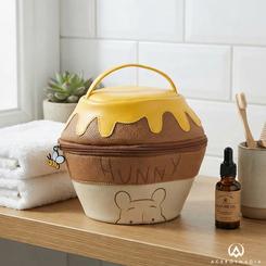 Neceser de viaje de Winnie the Pooh de Disney, con forma inspirada en un tarro de miel. Mide 18 x 20 x 18 cm, está fabricado en 100% PU e incorpora asa, cremallera y un tirador decorativo de abeja.