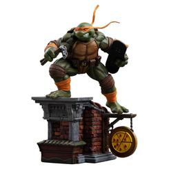 El tejado roto, la pizza colgando y la postura en pleno salto convierten esta estatua Michelangelo Tortugas Ninja en una escena con vida propia. No parece una figura colocada en una estantería, sino un instante congelado justo antes de que todo vuelva 