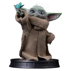 La estatua Grogu Butterfly Wonder detiene un instante casi ingrávido: una mano extendida, una mariposa azul y esa mirada enorme que convierte la curiosidad en escena. 